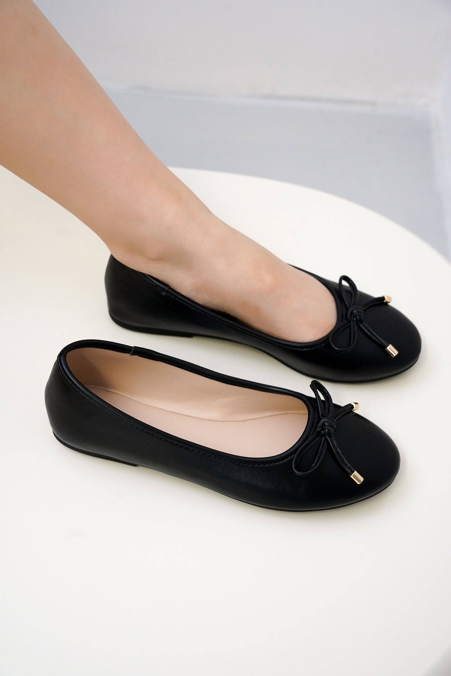Project Cloud black vegan leather ballet flats with bow detail, perfect for all-day comfort and style.