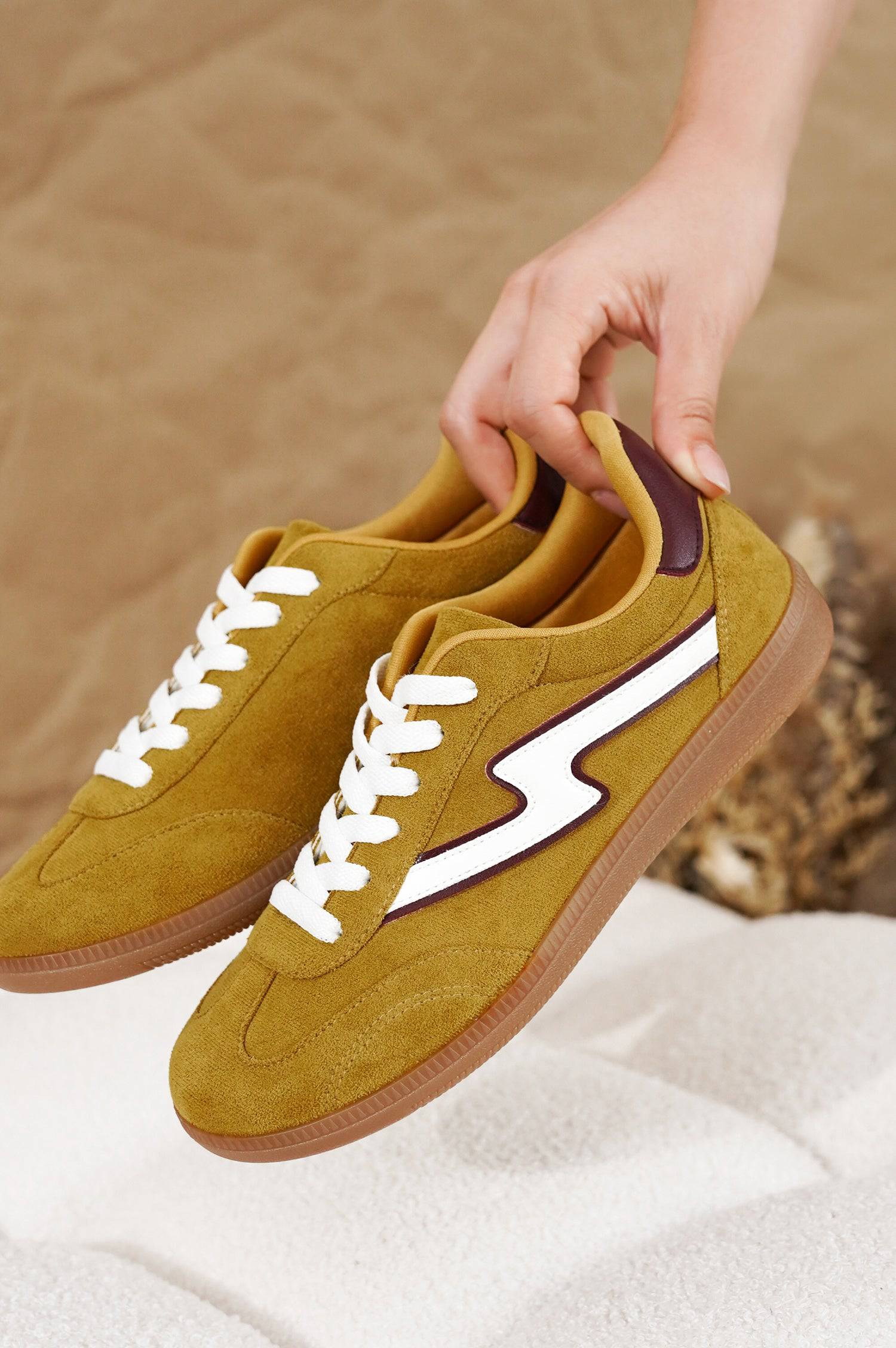 Irita mustard yellow suede sneakers with white lightning bolt. Women's Project Cloud shoes with brown sole.