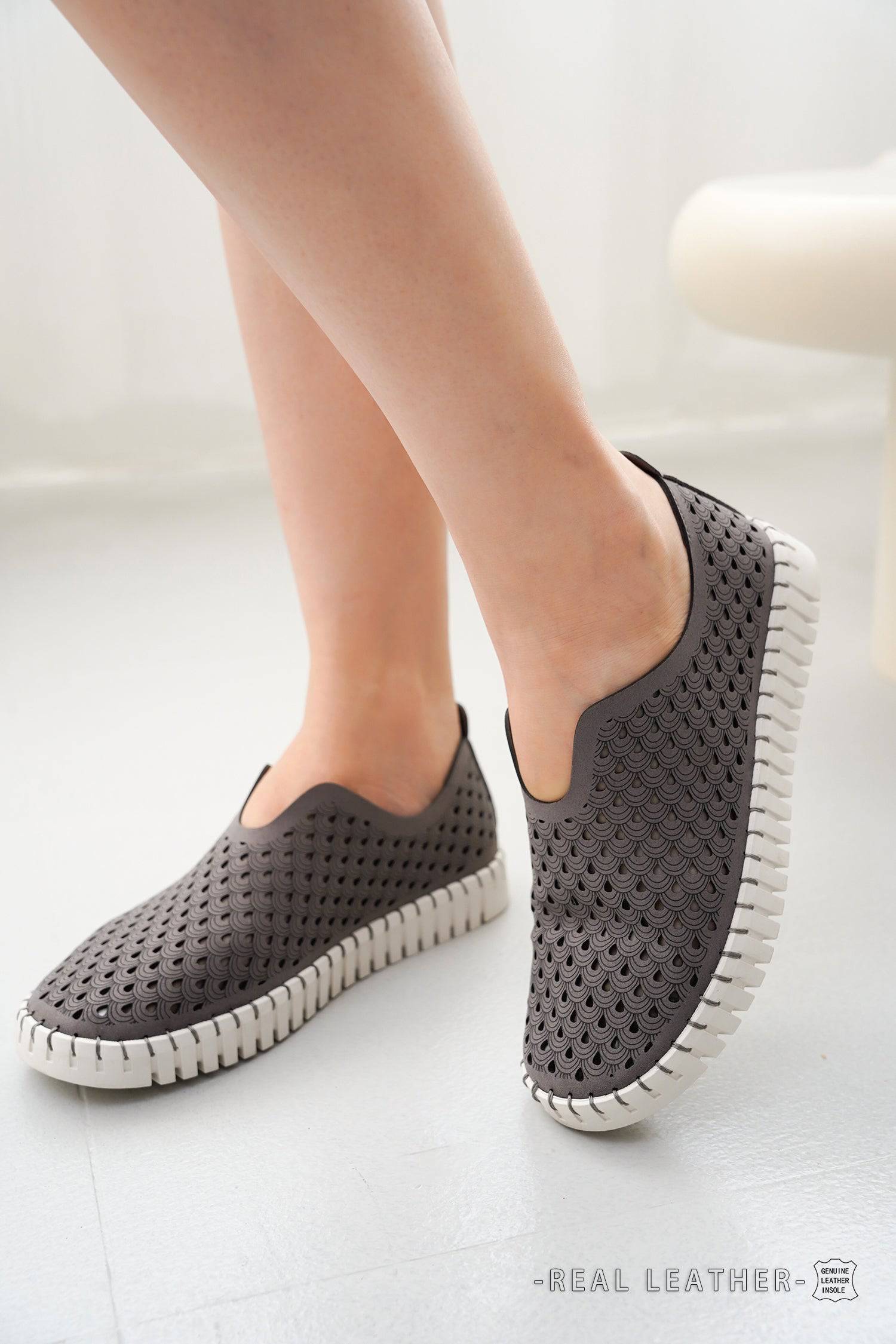 Grey women's Lily loafers with laser-cut design, leather insole. Lightweight, comfortable slip-on travel shoes. Real leather.