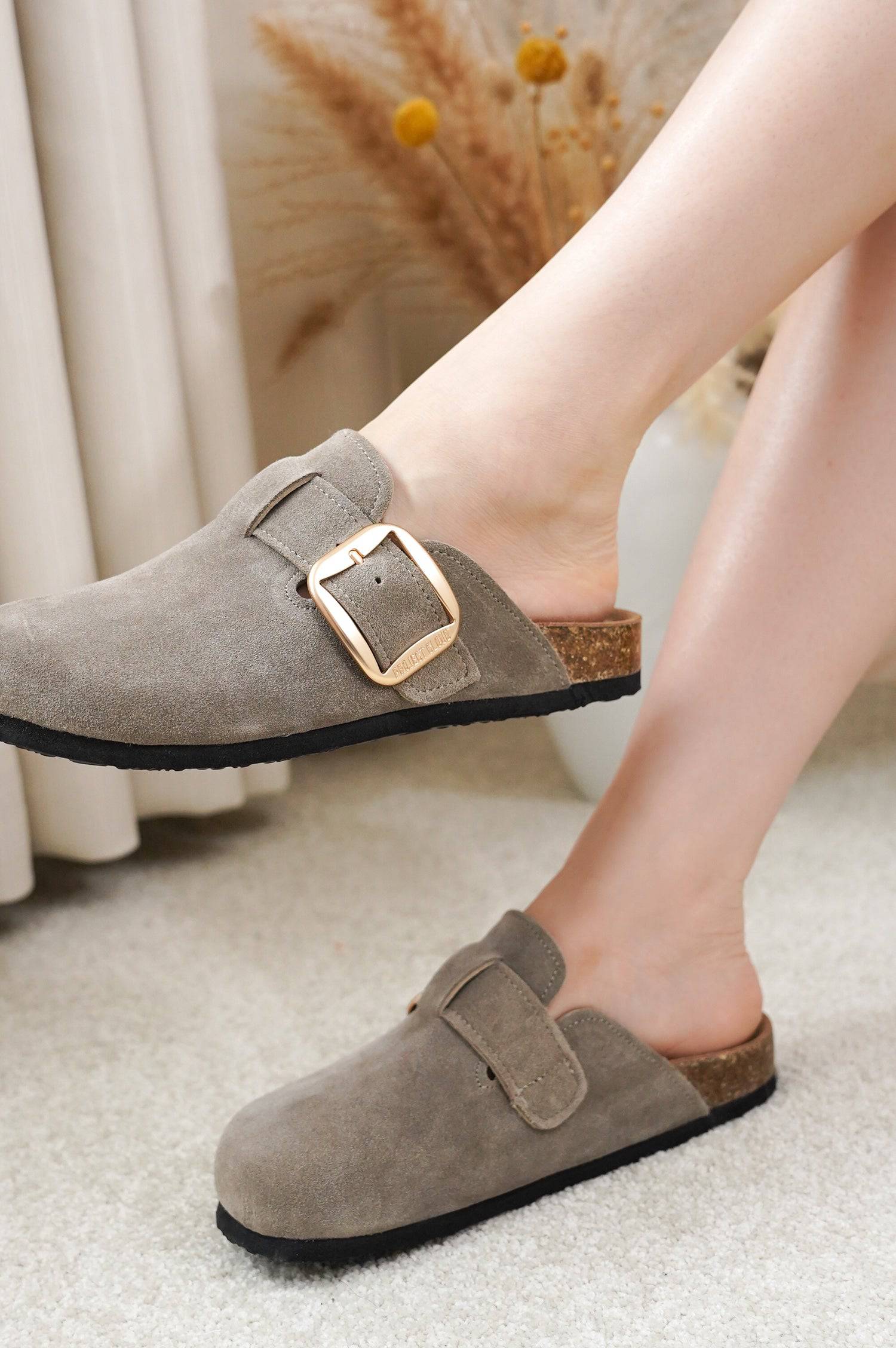 Project Cloud Manchester clogs in grey suede, with gold buckle, showing comfort and design.