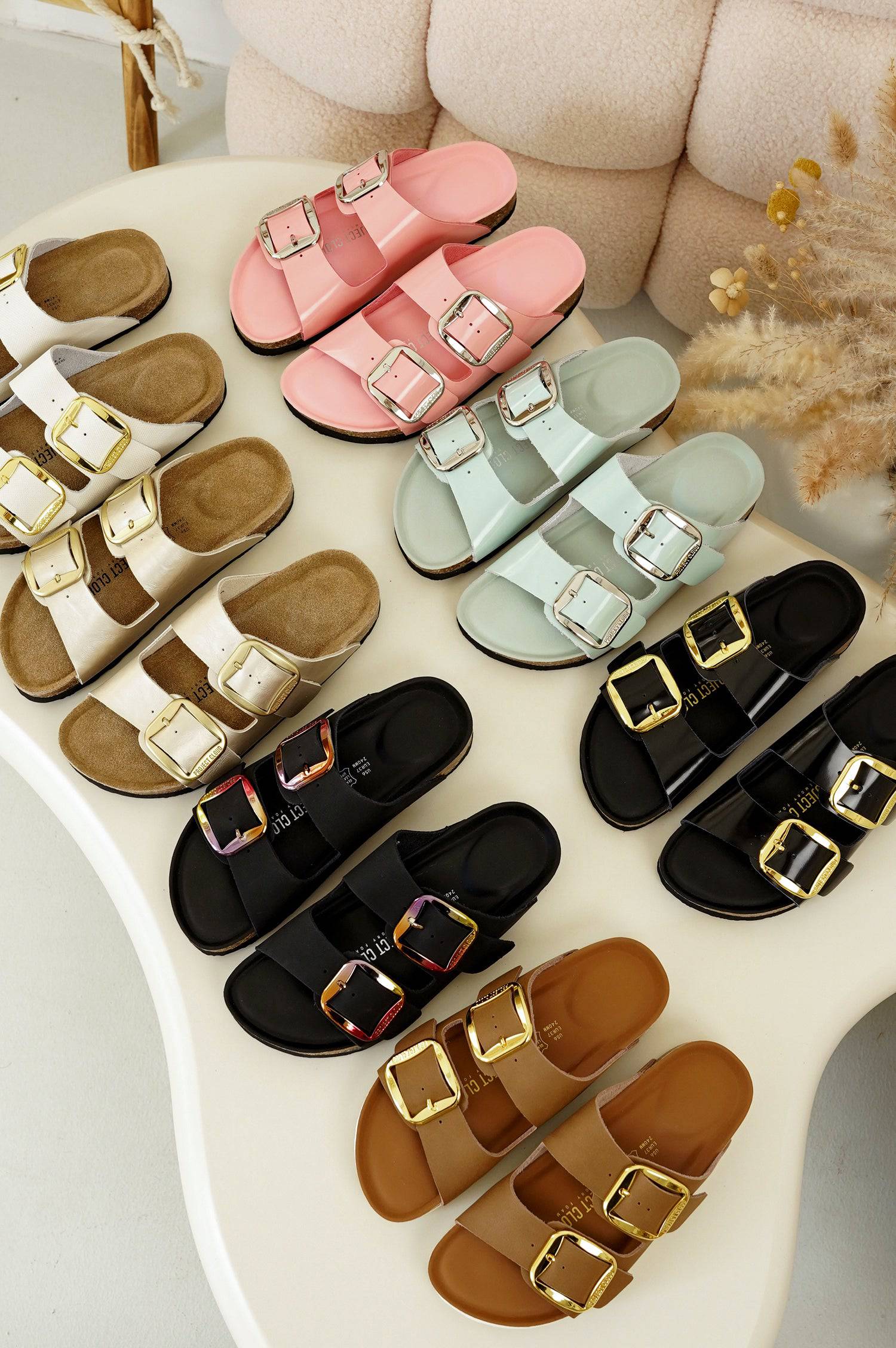 Women's Santorini sandals with gold buckles, memory foam Project Cloud slides for comfort and style.