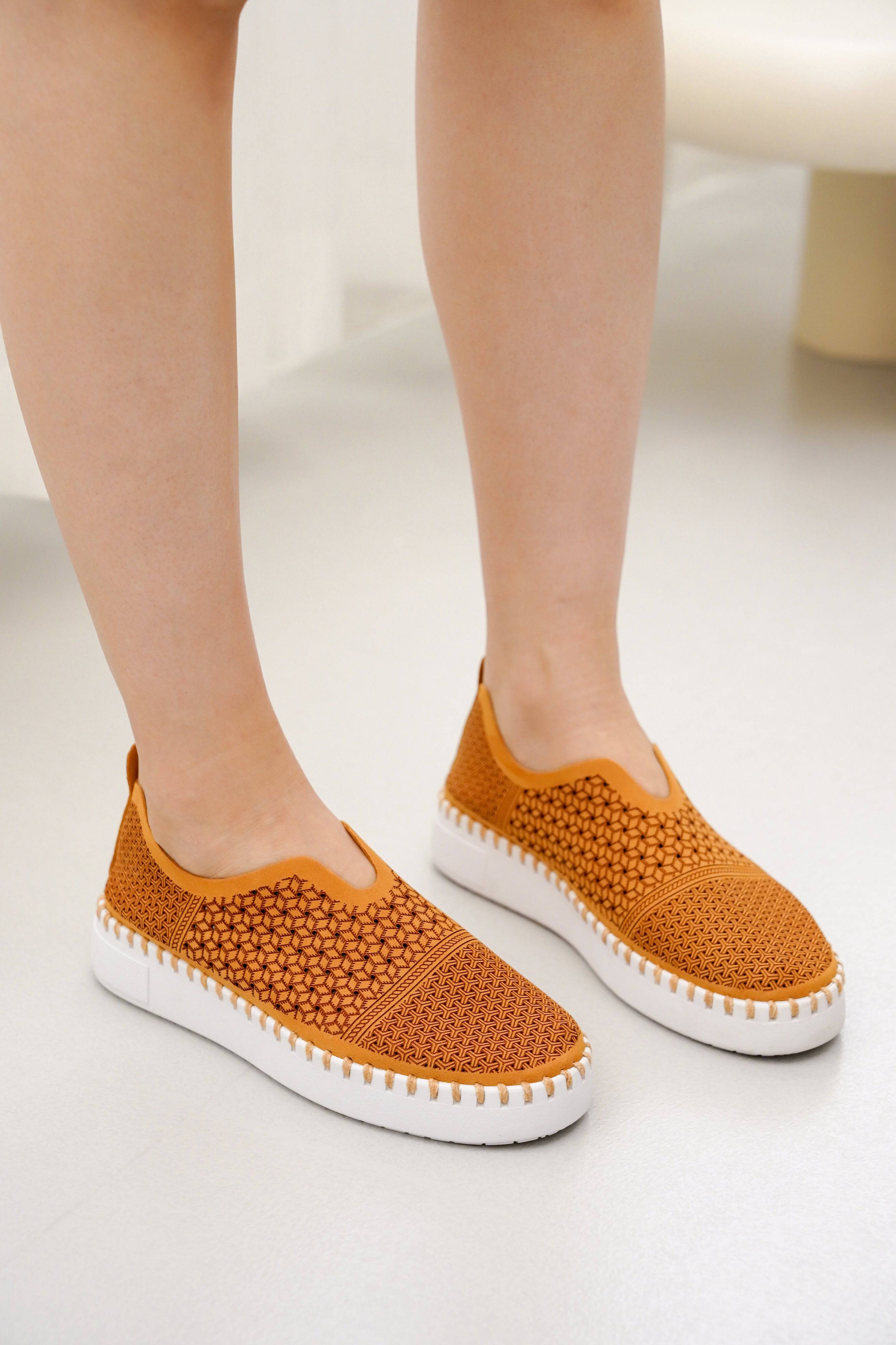 Aster Women's Orange Slip-on Sneakers with white soles. Comfortable, breathable, and stylish, perfect for sockless wear