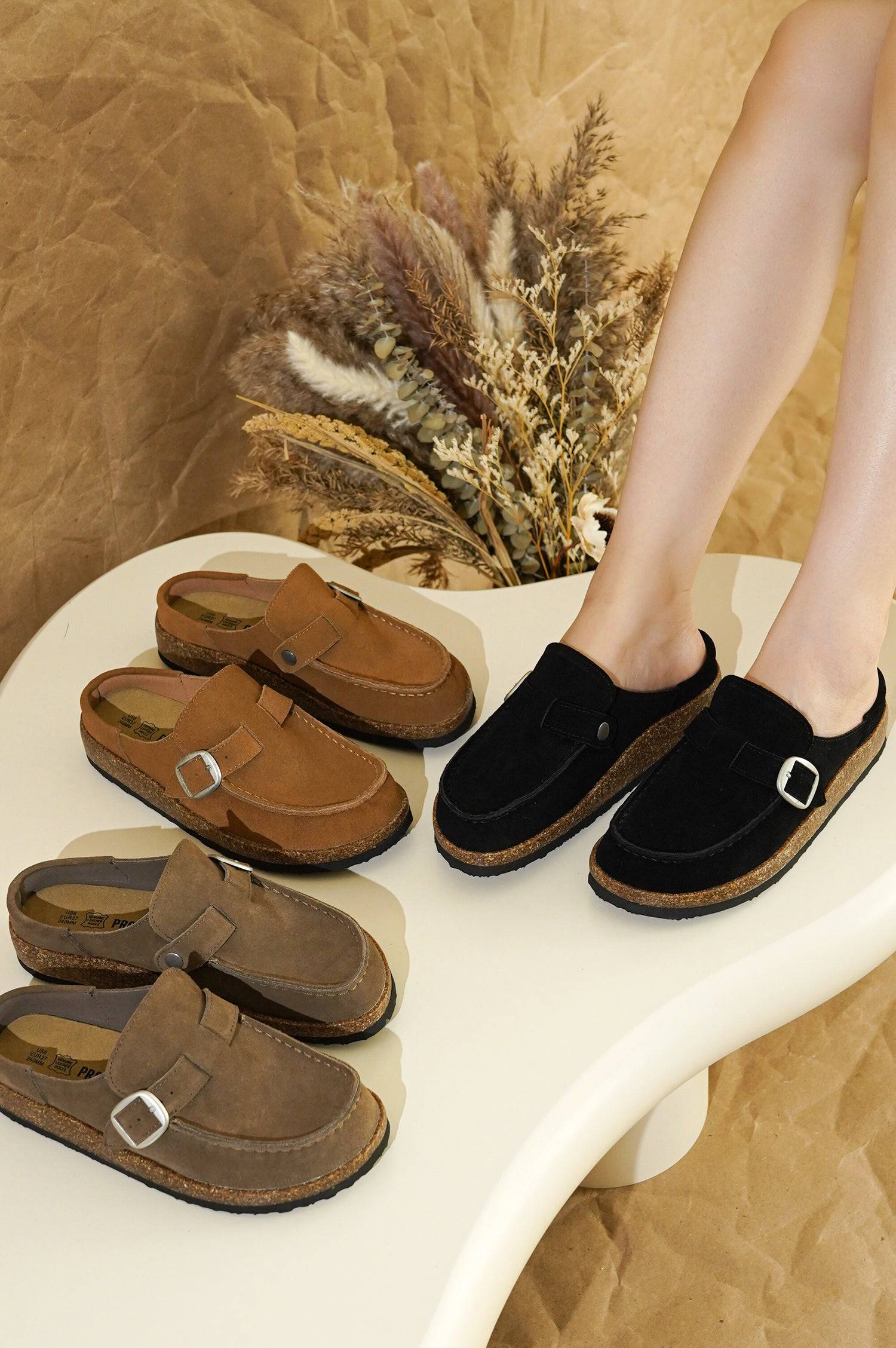 Project Cloud Carline clogs for women in black and brown suede with buckle detail and cork sole.