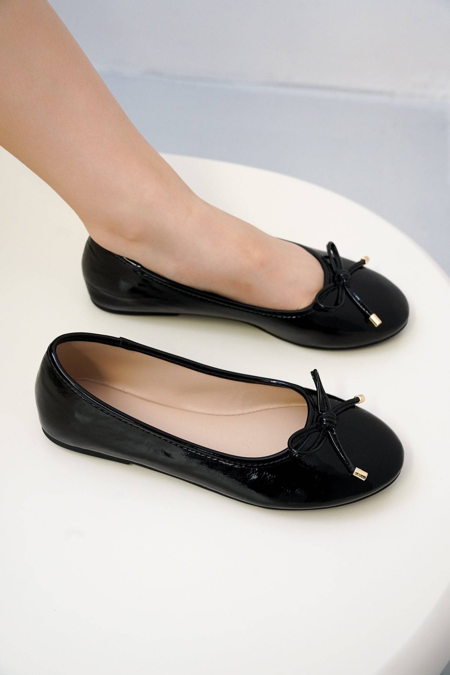 Black Project Cloud ballet flats with bow detail, highlighting comfort and style.