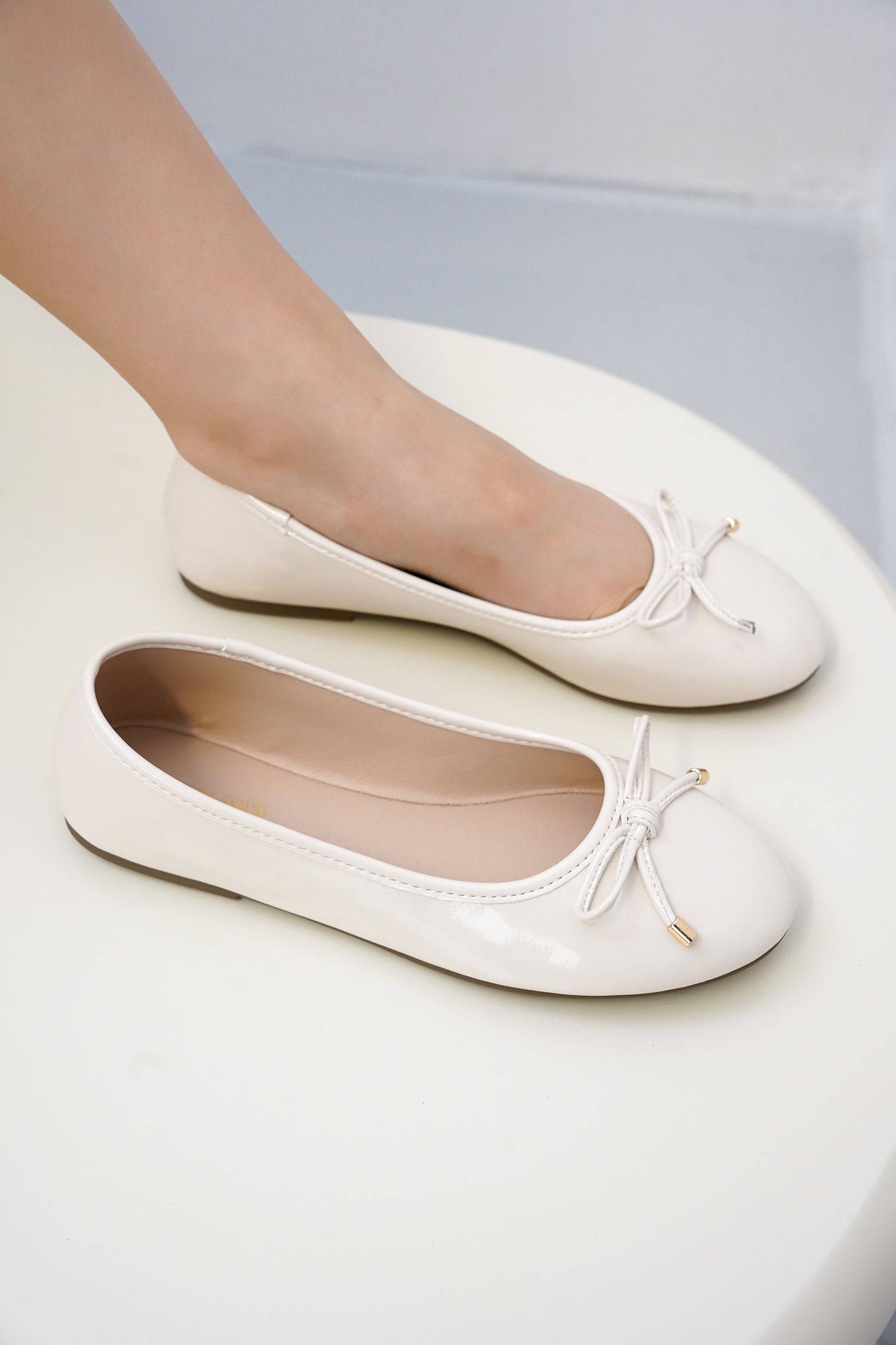 Project Cloud white ballet flats with bow detail and gold accents. Comfortable vegan leather flats, perfect for any occasion.