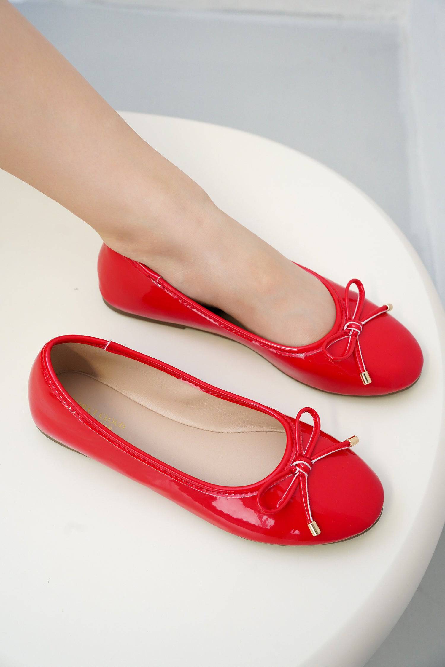 Project Cloud red ballet flats with bow detail, showing the elegant design and comfort.