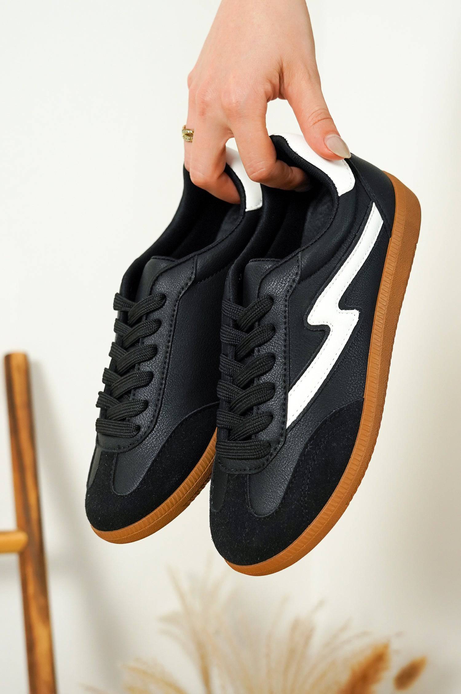 Black Irita sneakers with lightning bolt design, brown sole. Women's lace-up Project Cloud shoes.