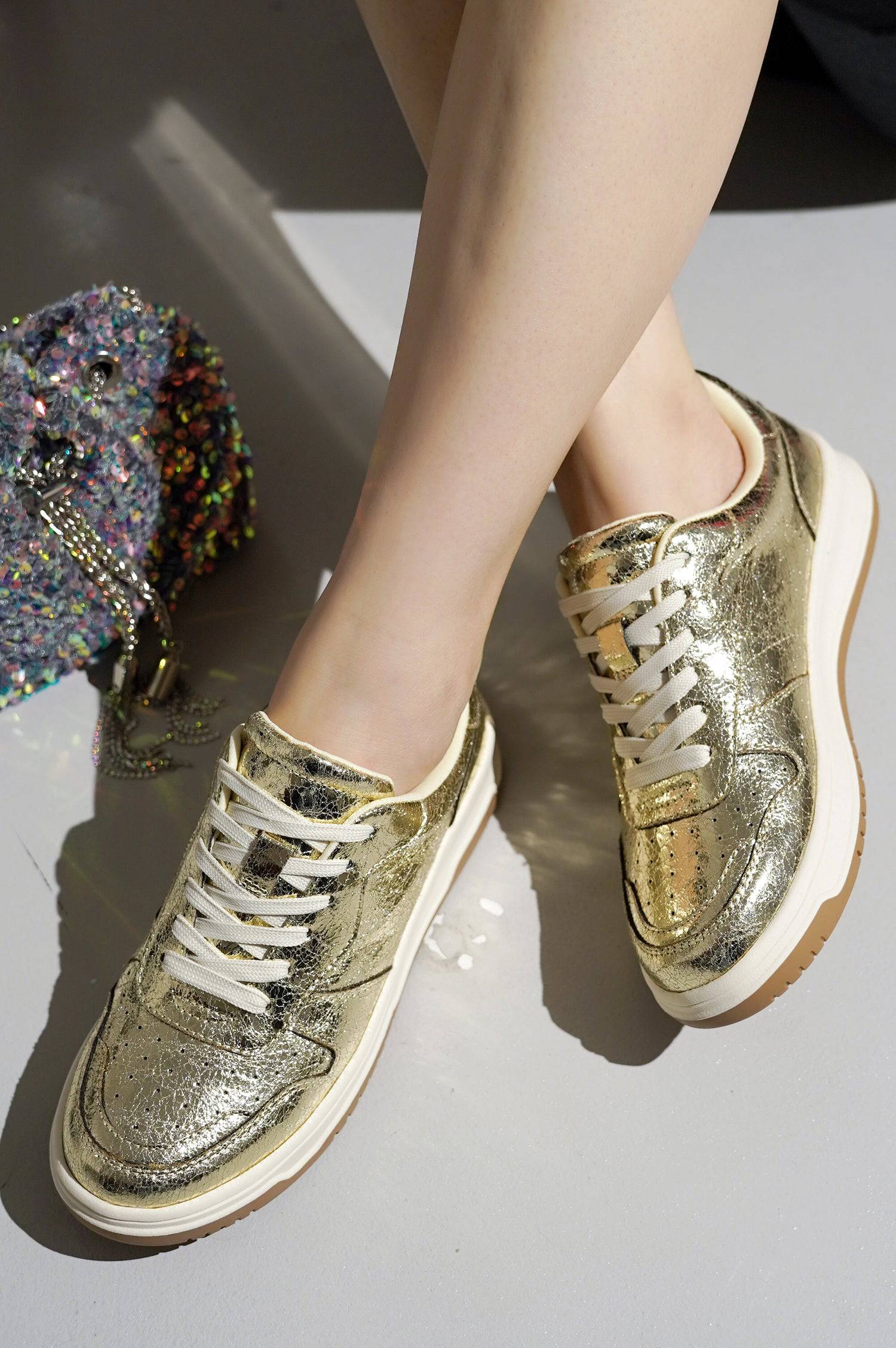 Golden metallic Kiki women's sneakers, lace-up design, stylish and comfortable women's fashion.