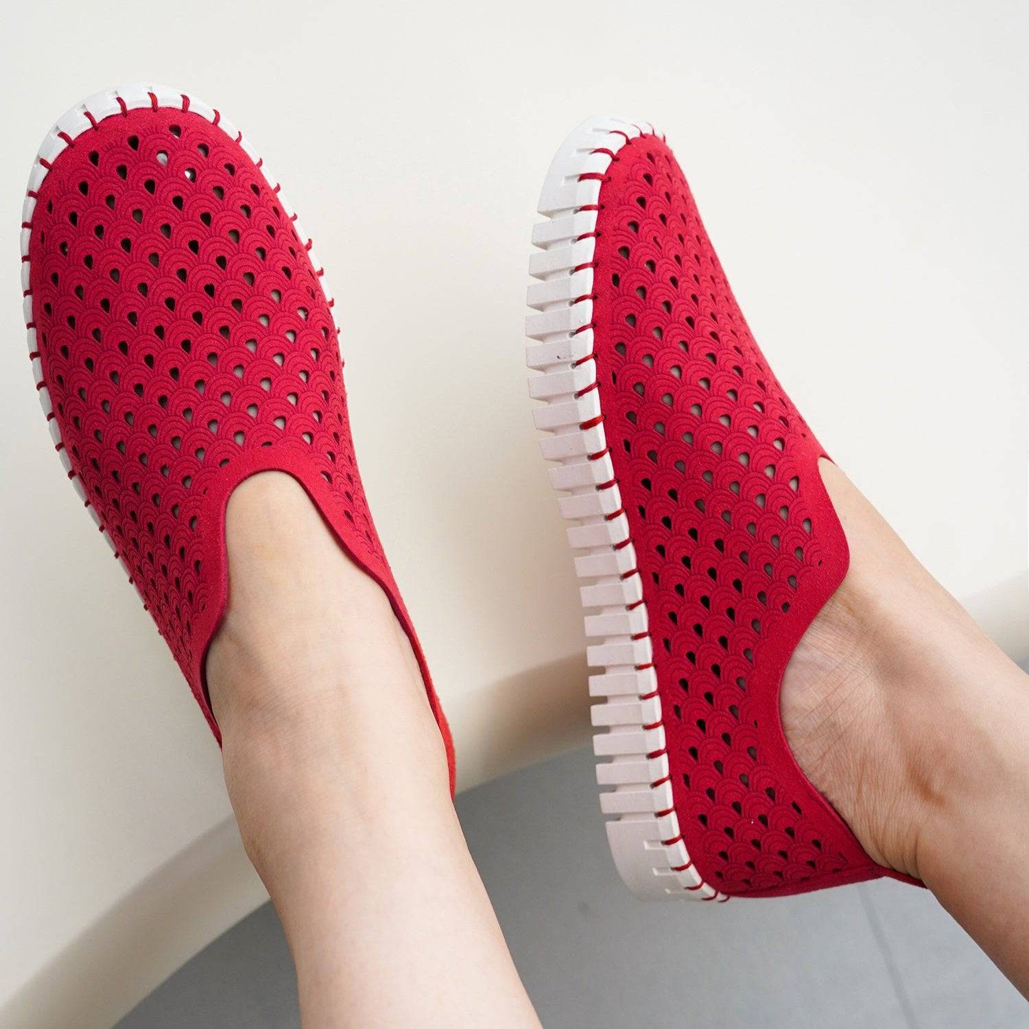 Red slip-on loafers for women with perforated design, white sole, comfortable and stylish.