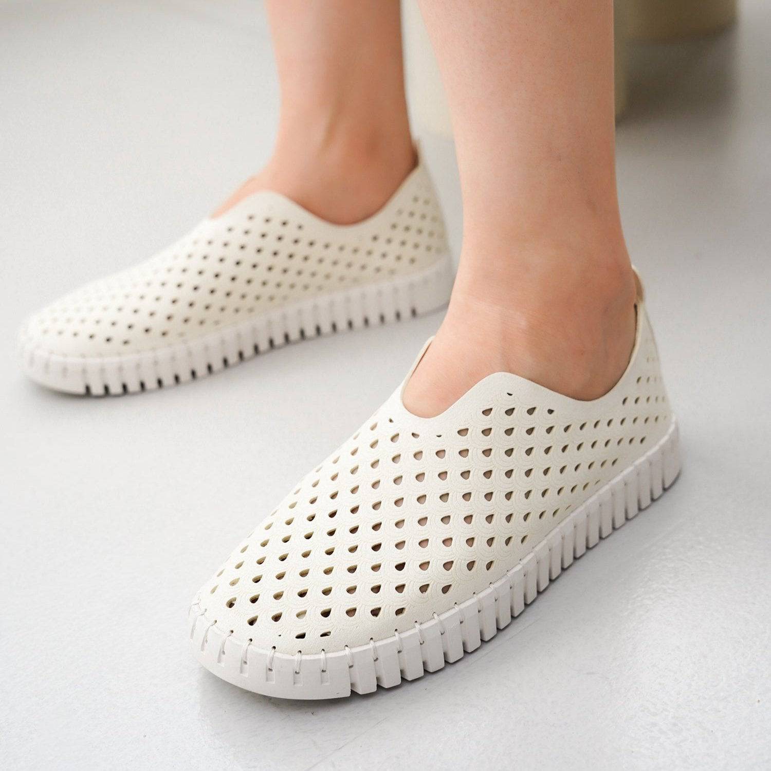 White perforated slip-on women's loafers, lightweight design, comfortable leather insole flats.