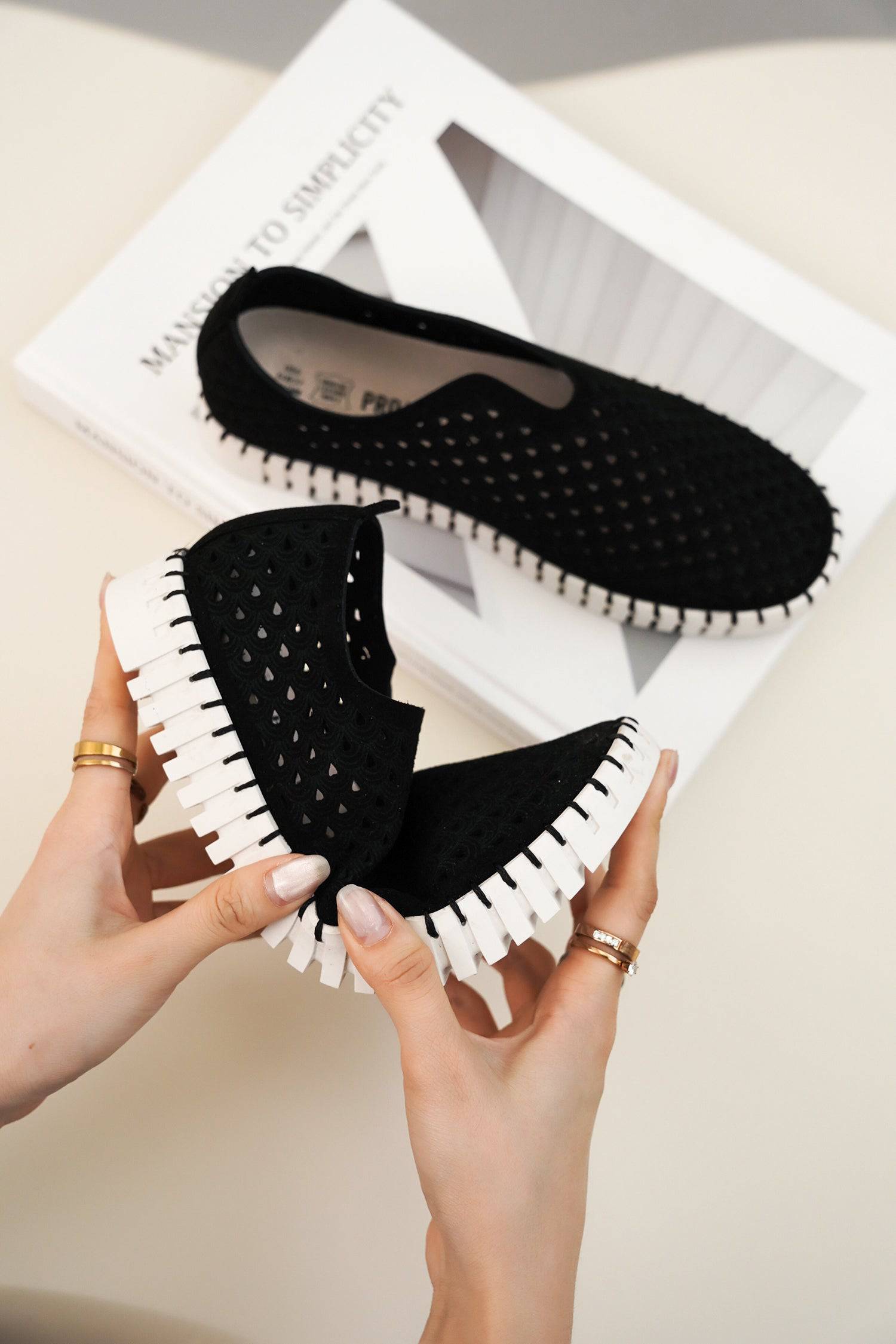 Women's black perforated slip-on Lily loafers, white sole, showcasing comfort and lightweight design.