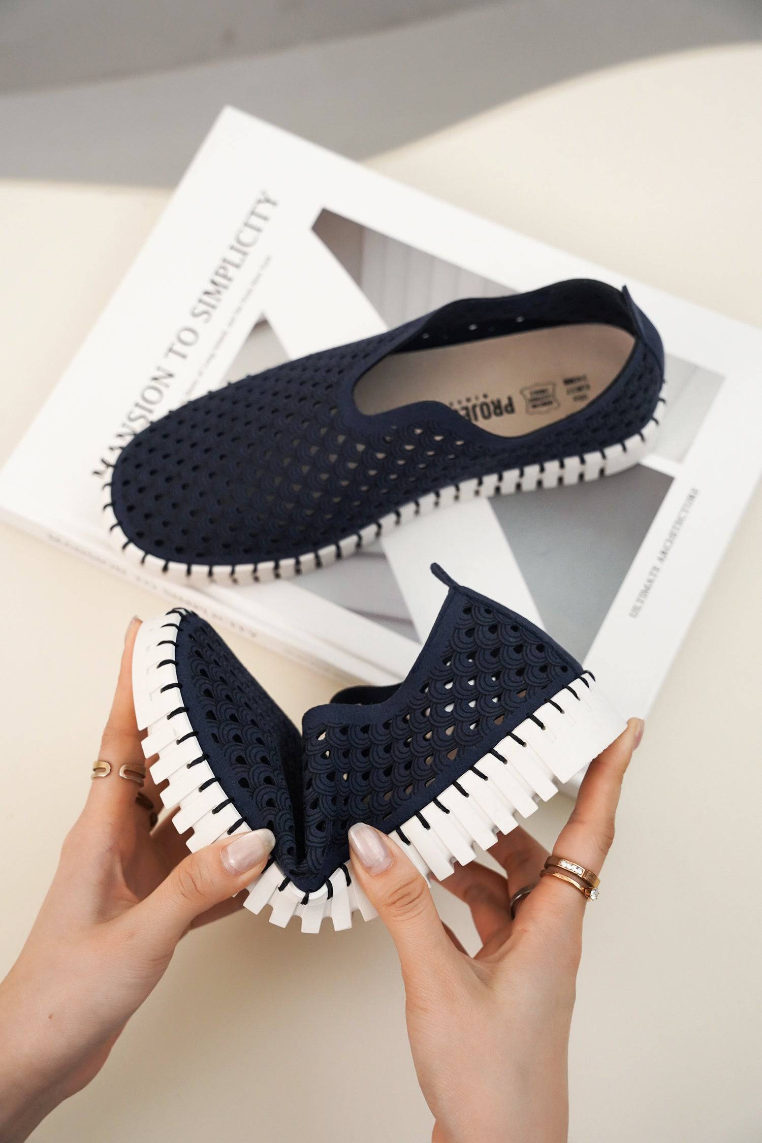 Navy blue perforated Lily loafers, white sole. Lightweight, comfortable slip-on shoes for women.