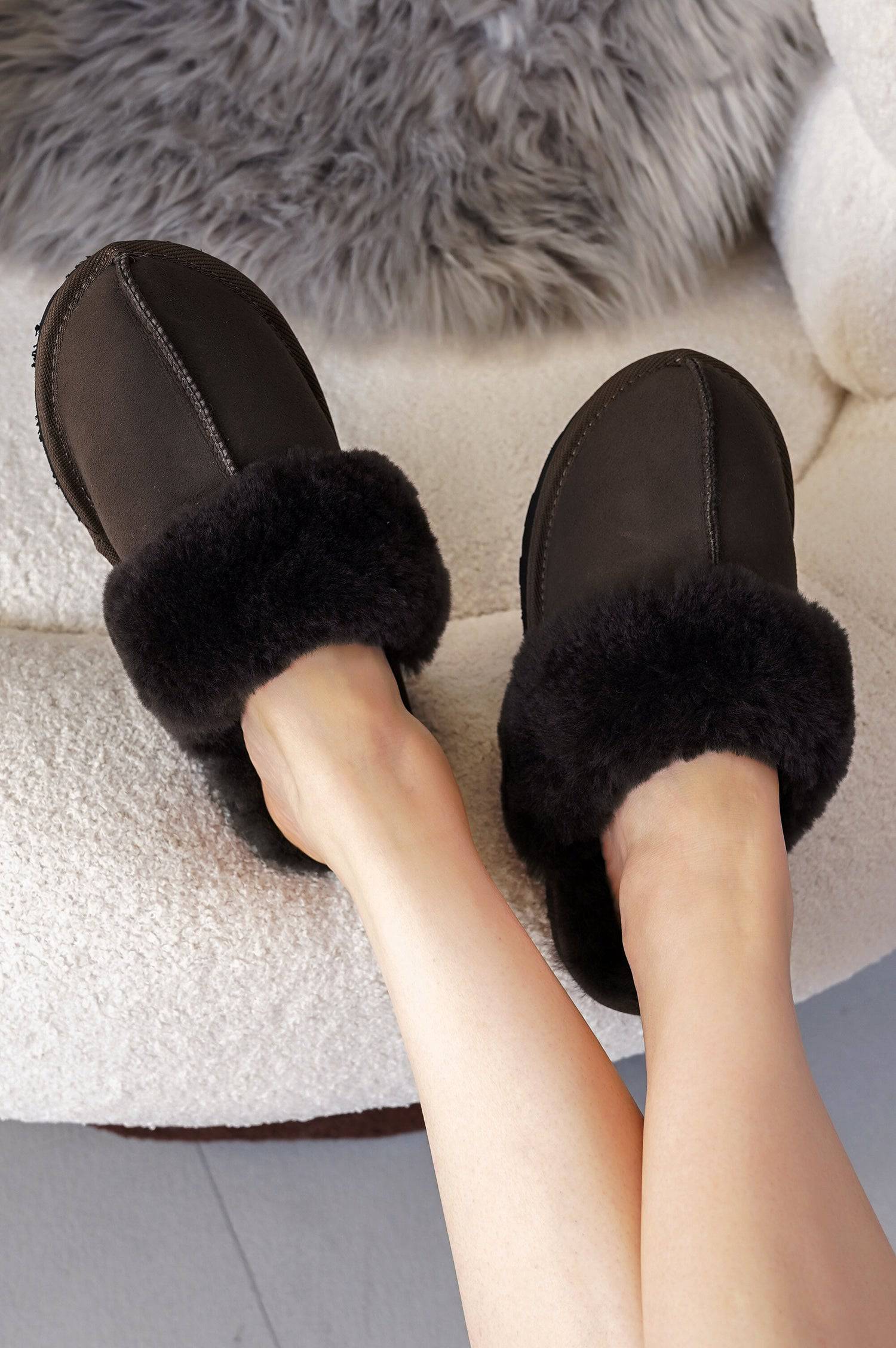 Project Cloud Lynsey Slippers in Black: Suede slippers with sheepskin fur lining and memory foam, showing feet.