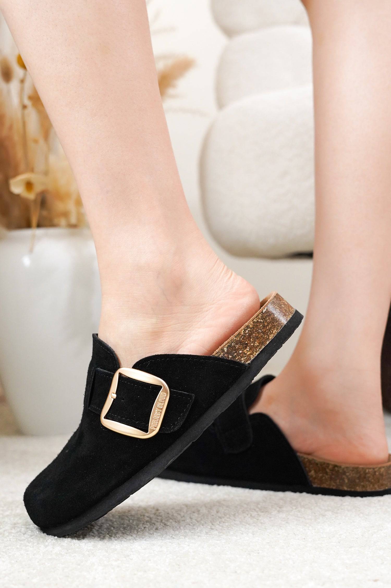 Project Cloud Manchester clogs for women in black suede with buckle detail. Features memory foam insole and cork sole.