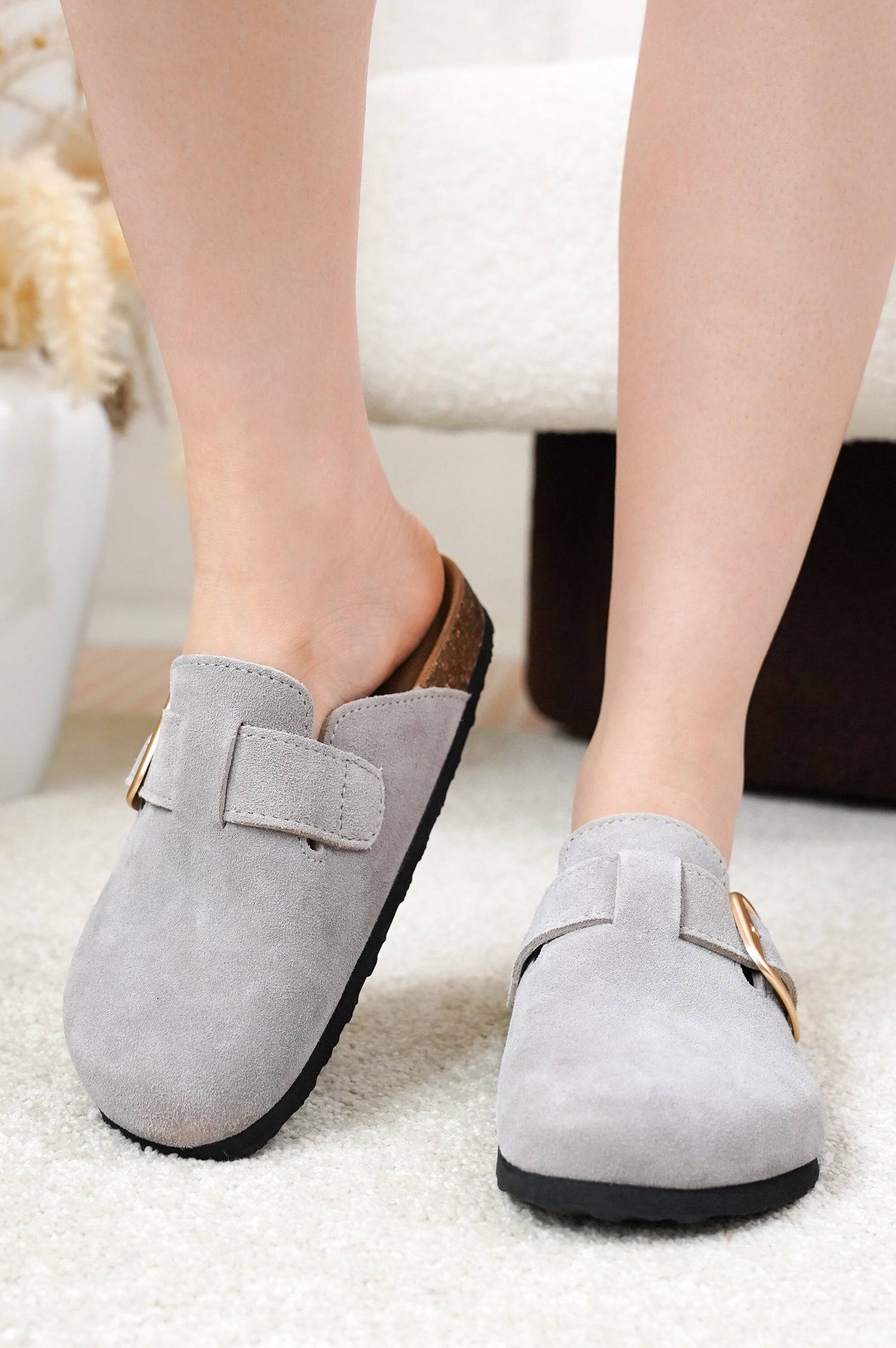 Grey suede Project Cloud Manchester clogs with gold buckle, close-up of material and design.