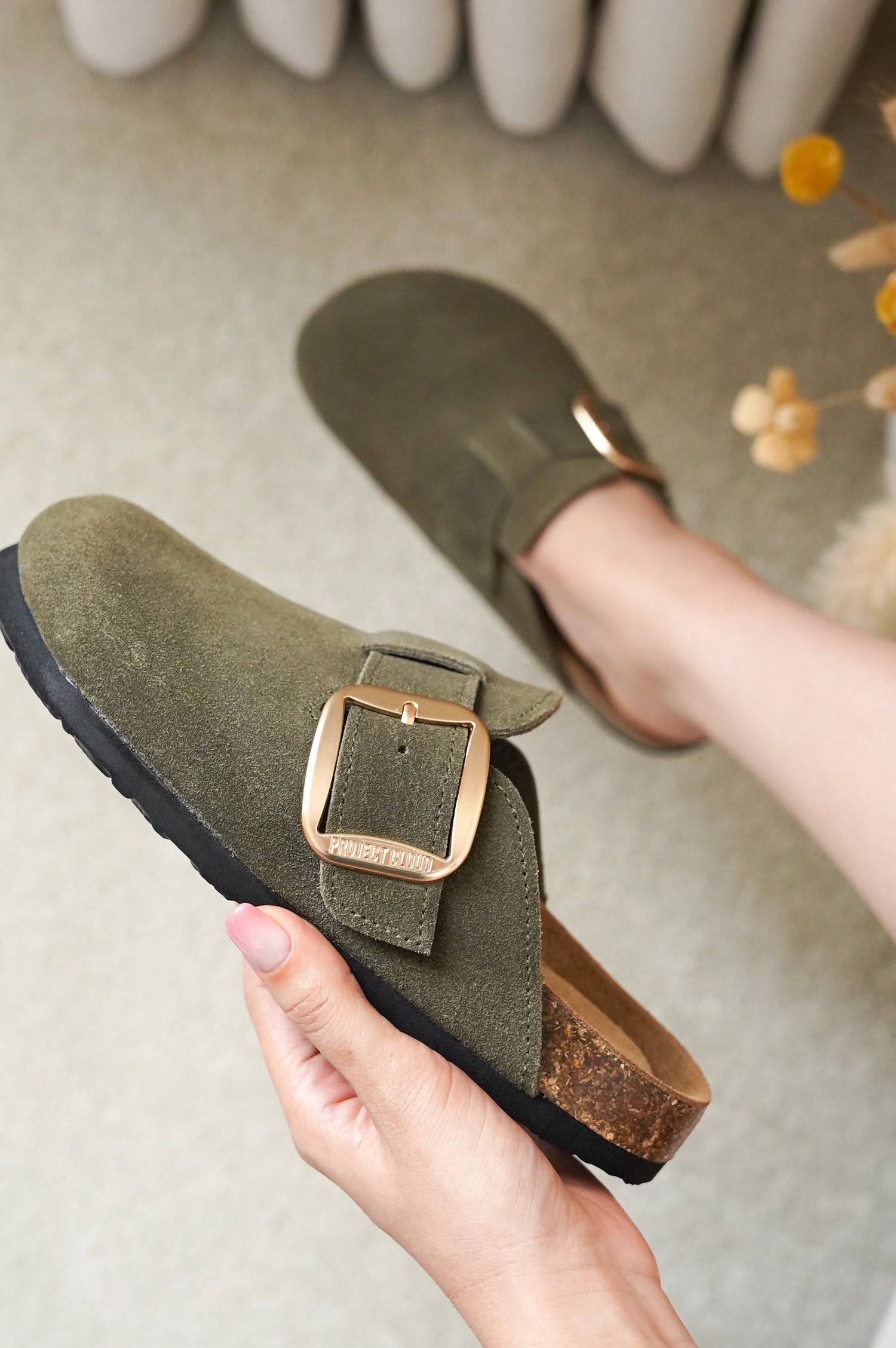 Olive green suede Project Cloud Manchester clogs with gold buckle. Genuine leather comfort.
